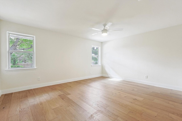 empty room featuring ceiling fan, plenty of natural light, and light hardwood / wood-style flooring