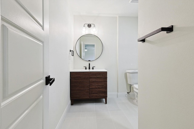 bathroom with toilet, tile patterned floors, and vanity