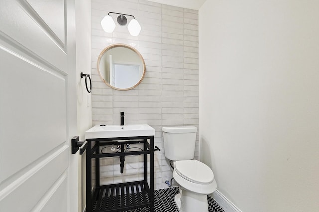 bathroom with sink, tile walls, toilet, and tile patterned flooring