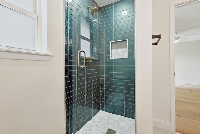 bathroom with ceiling fan and an enclosed shower