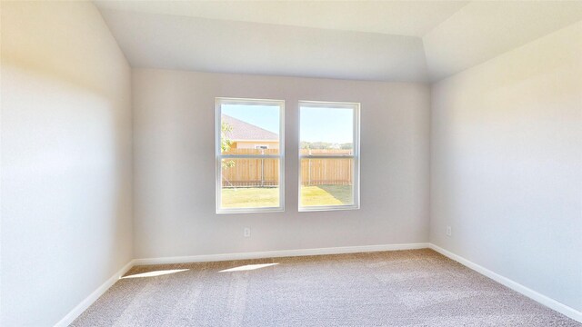 spare room featuring light hardwood / wood-style floors and lofted ceiling