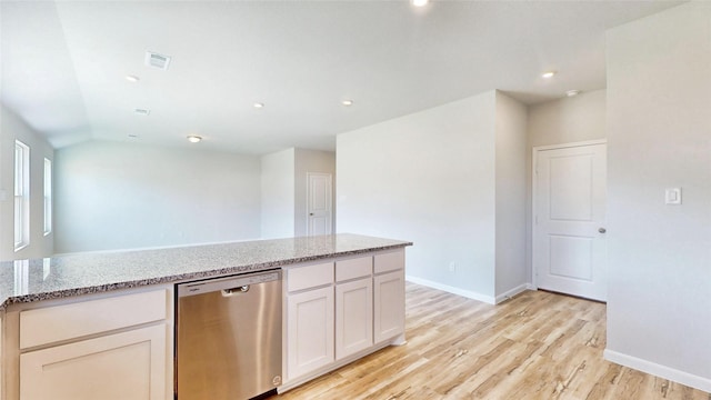 kitchen with white cabinetry, vaulted ceiling, stainless steel dishwasher, light hardwood / wood-style flooring, and light stone counters