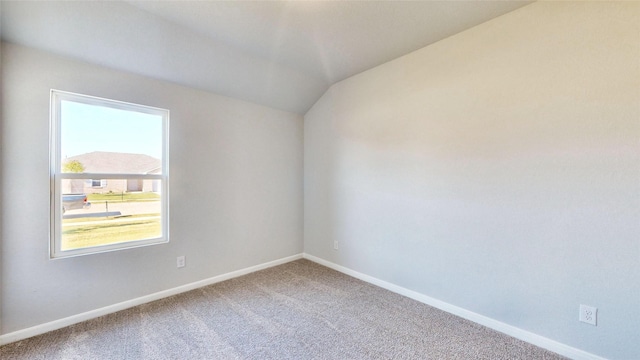 unfurnished room with carpet floors and vaulted ceiling