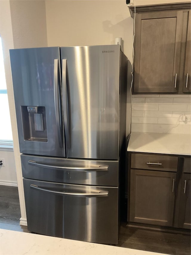 kitchen with dark wood-type flooring, backsplash, stainless steel refrigerator with ice dispenser, and dark brown cabinets