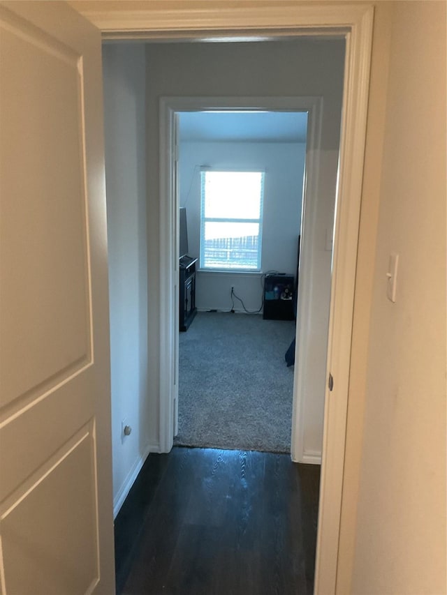 hallway featuring dark colored carpet