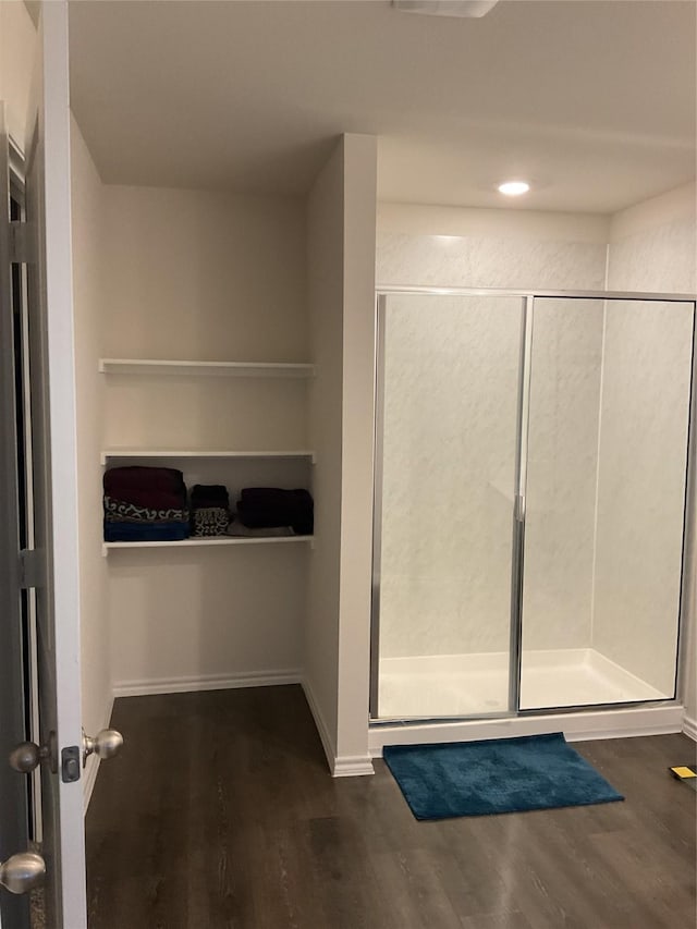 bathroom with hardwood / wood-style floors and a shower with door