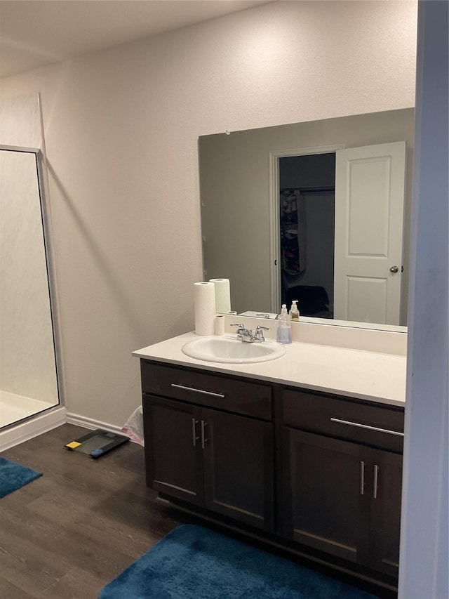 bathroom with wood-type flooring, an enclosed shower, and vanity