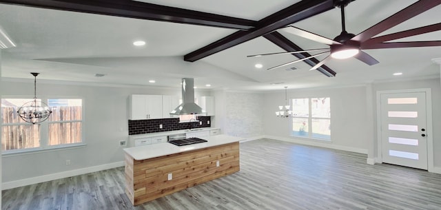 kitchen with island range hood, backsplash, vaulted ceiling with beams, white cabinets, and a center island