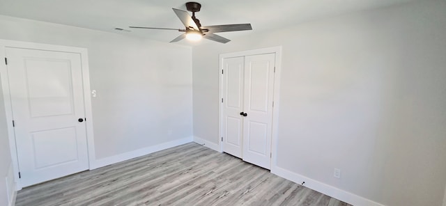 unfurnished bedroom with ceiling fan, light hardwood / wood-style flooring, and a closet