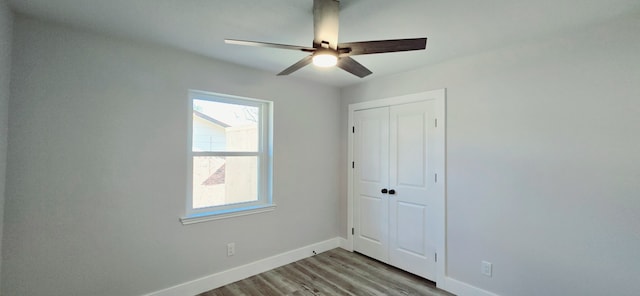 unfurnished bedroom with ceiling fan, light wood-type flooring, and a closet