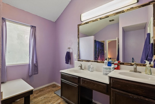 bathroom featuring vaulted ceiling, hardwood / wood-style floors, and vanity