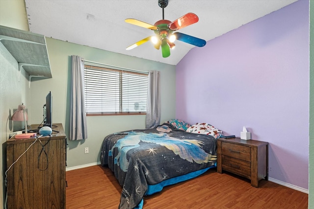 bedroom with vaulted ceiling, ceiling fan, and dark hardwood / wood-style flooring