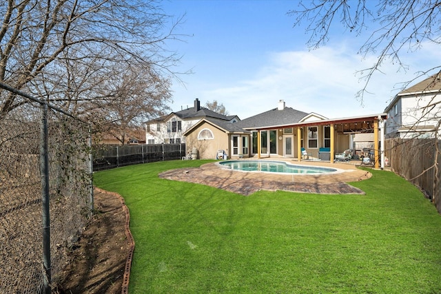 back of property with ceiling fan, a yard, a patio area, and a fenced in pool