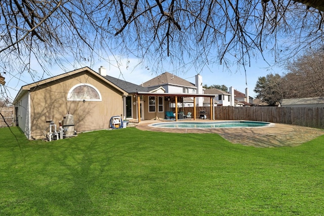 rear view of property with a fenced in pool and a lawn