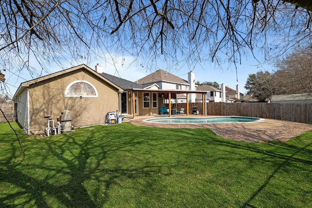 back of property with a yard, a patio area, and a fenced in pool