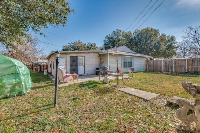 rear view of property with a yard and a patio