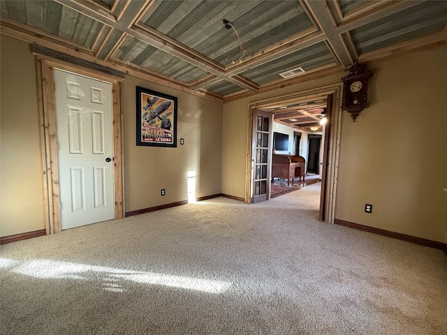 empty room with french doors, carpet, and coffered ceiling