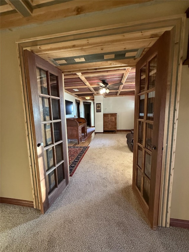 hallway with carpet floors and beamed ceiling