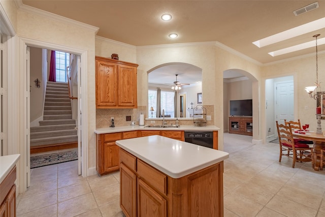 kitchen with black dishwasher, sink, hanging light fixtures, ceiling fan with notable chandelier, and a center island