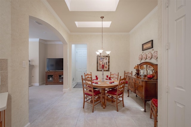 tiled dining room featuring a chandelier, a skylight, and ornamental molding