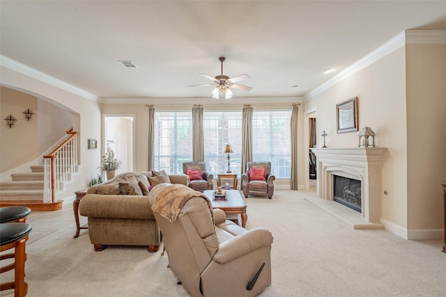 carpeted living room featuring ceiling fan and ornamental molding