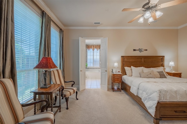 bedroom with light carpet, ceiling fan, crown molding, and ensuite bath