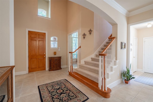 tiled entryway featuring a wealth of natural light and crown molding