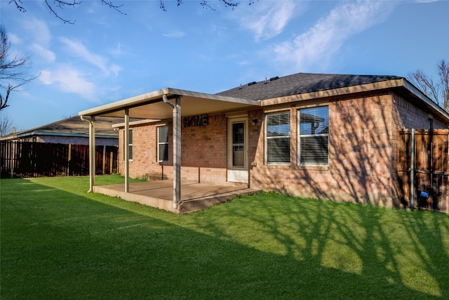 back of house with a patio area and a lawn