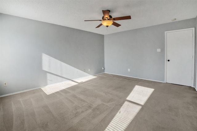 empty room with ceiling fan, light colored carpet, and a textured ceiling