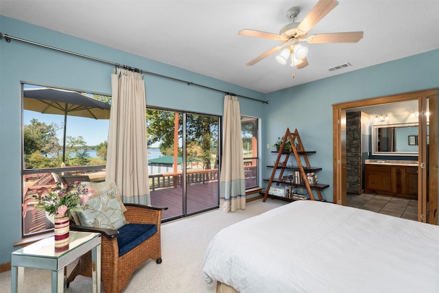 carpeted bedroom featuring ceiling fan, ensuite bathroom, and access to outside