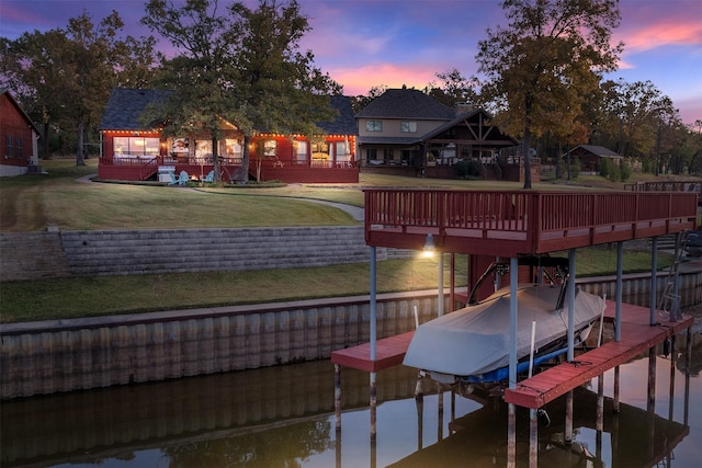 dock area with a water view and a lawn