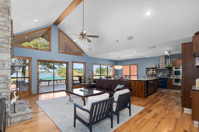 living room with light hardwood / wood-style floors, ceiling fan, sink, high vaulted ceiling, and beamed ceiling