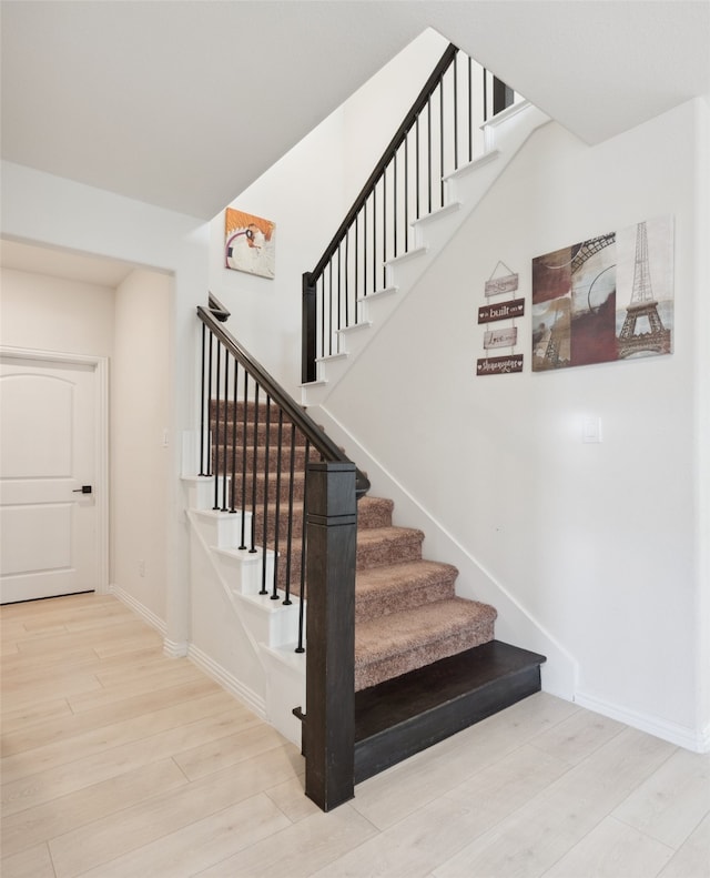 staircase with hardwood / wood-style floors