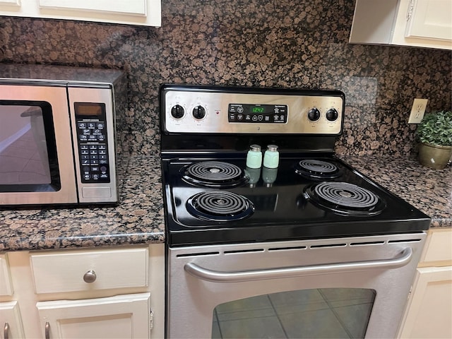 kitchen featuring backsplash, stainless steel appliances, and dark stone countertops