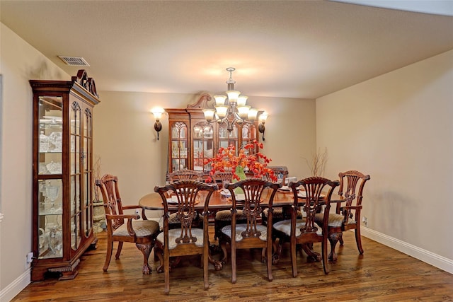 dining room with an inviting chandelier and dark hardwood / wood-style floors