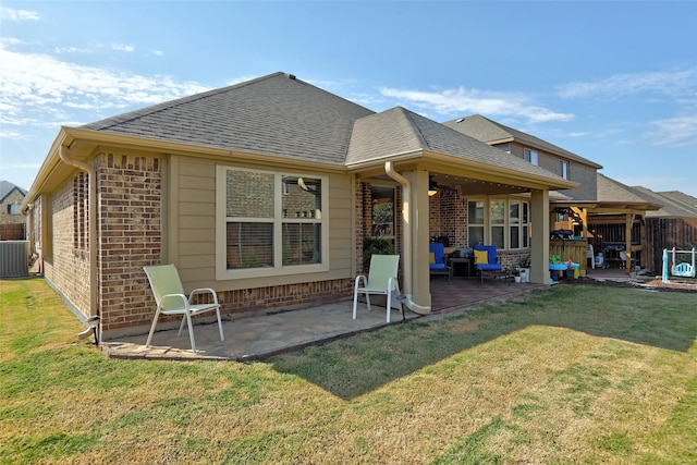 rear view of property with a lawn and a patio