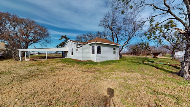 view of side of property featuring a carport and a yard