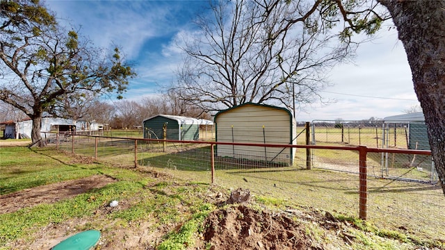 view of outbuilding featuring a rural view and a lawn