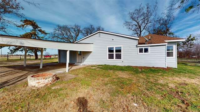 back of house with a lawn and a carport