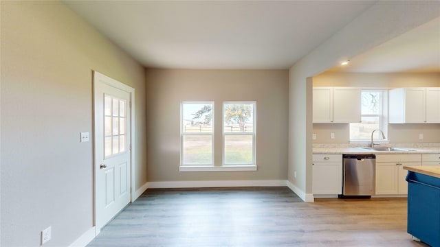 kitchen with light hardwood / wood-style floors, dishwasher, white cabinets, and sink