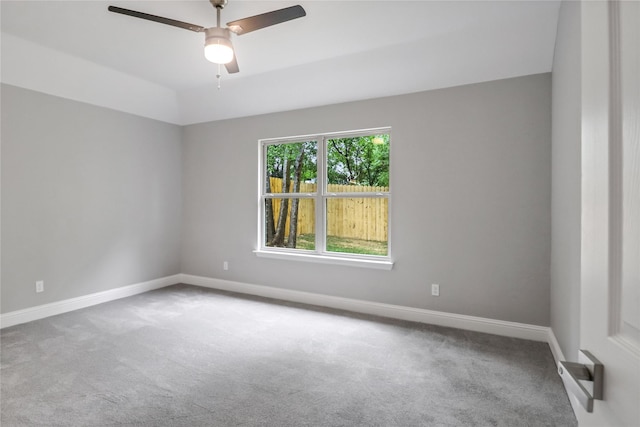 carpeted spare room with ceiling fan