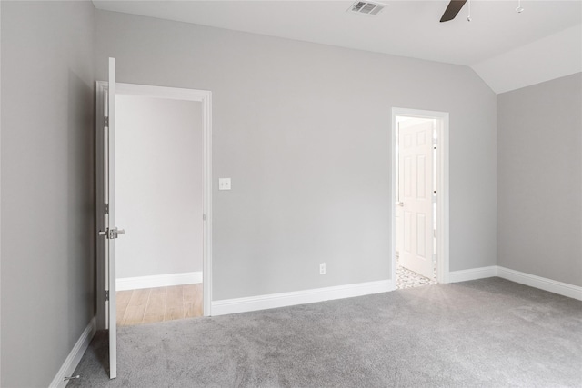 carpeted empty room with vaulted ceiling and ceiling fan