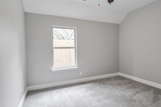 carpeted empty room featuring ceiling fan and vaulted ceiling