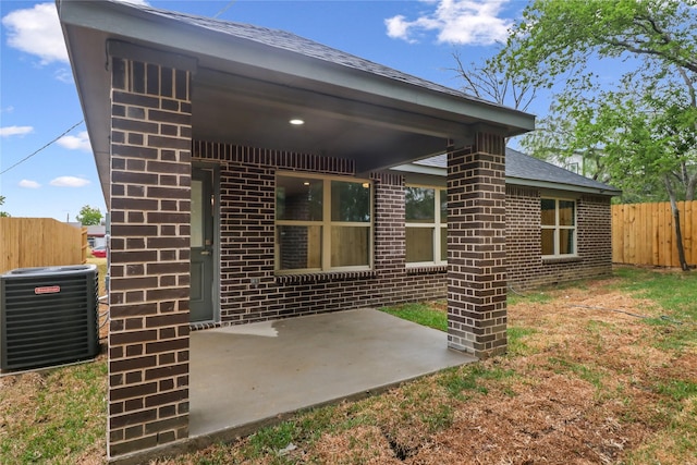 rear view of property with a patio area and central AC