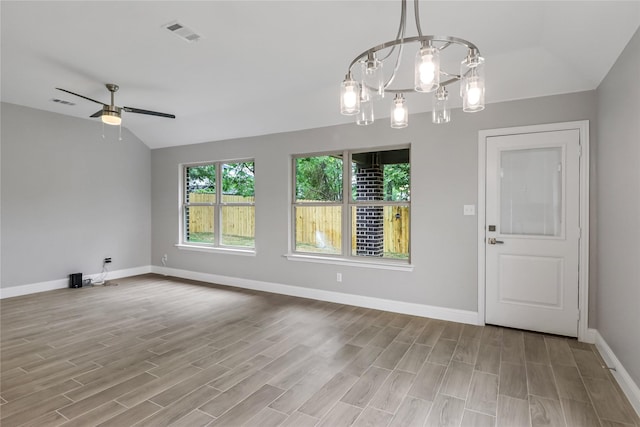 unfurnished dining area featuring vaulted ceiling, ceiling fan with notable chandelier, and light hardwood / wood-style flooring