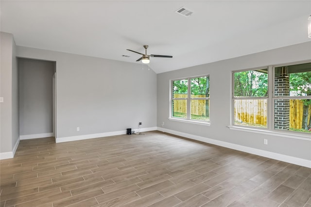 unfurnished room with ceiling fan, vaulted ceiling, and light hardwood / wood-style flooring