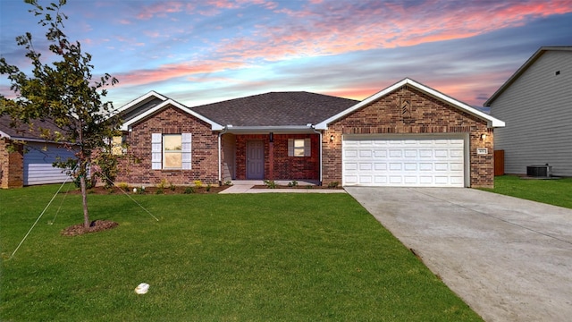 single story home featuring a garage and a lawn