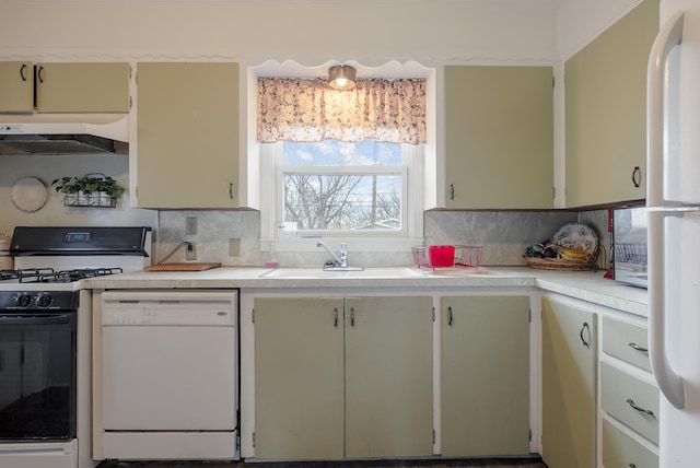 kitchen featuring decorative backsplash, sink, and white appliances