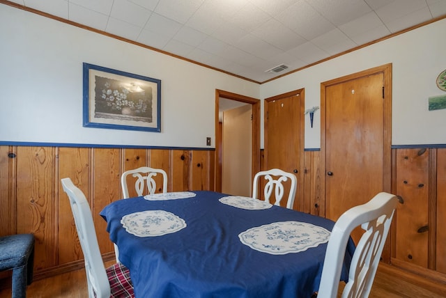 dining area featuring ornamental molding and hardwood / wood-style floors