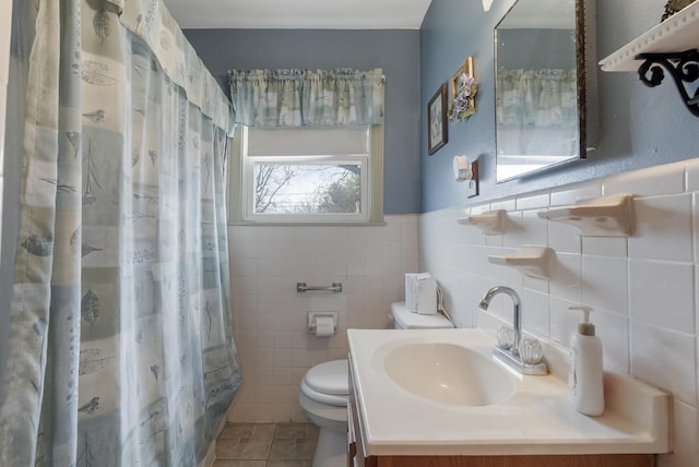 bathroom featuring toilet, vanity, tile walls, tile patterned flooring, and a shower with curtain